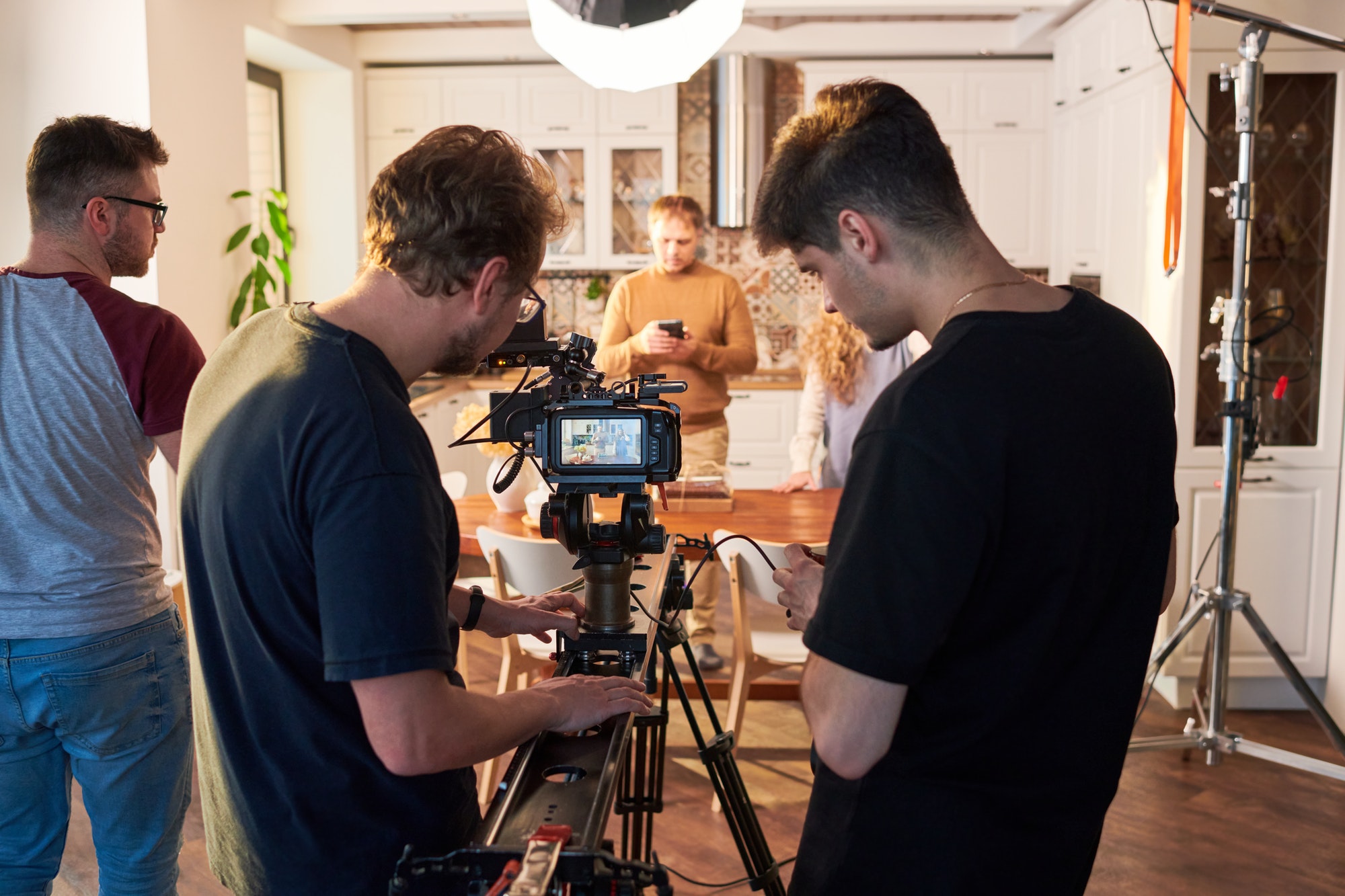 rear-view-of-videographer-and-his-assistant-adjusting-video-camera-for-shooting.jpg